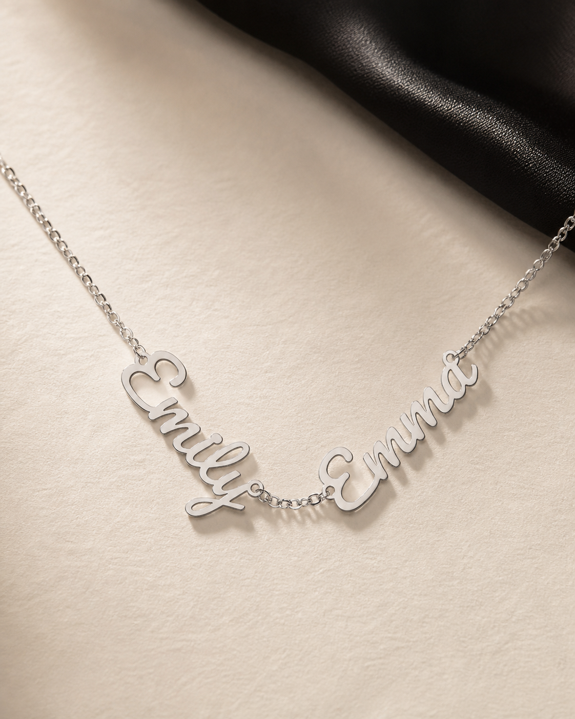 Names Between Us Necklace in polished stainless steel, two personalized script nameplates joined by a fine center chain